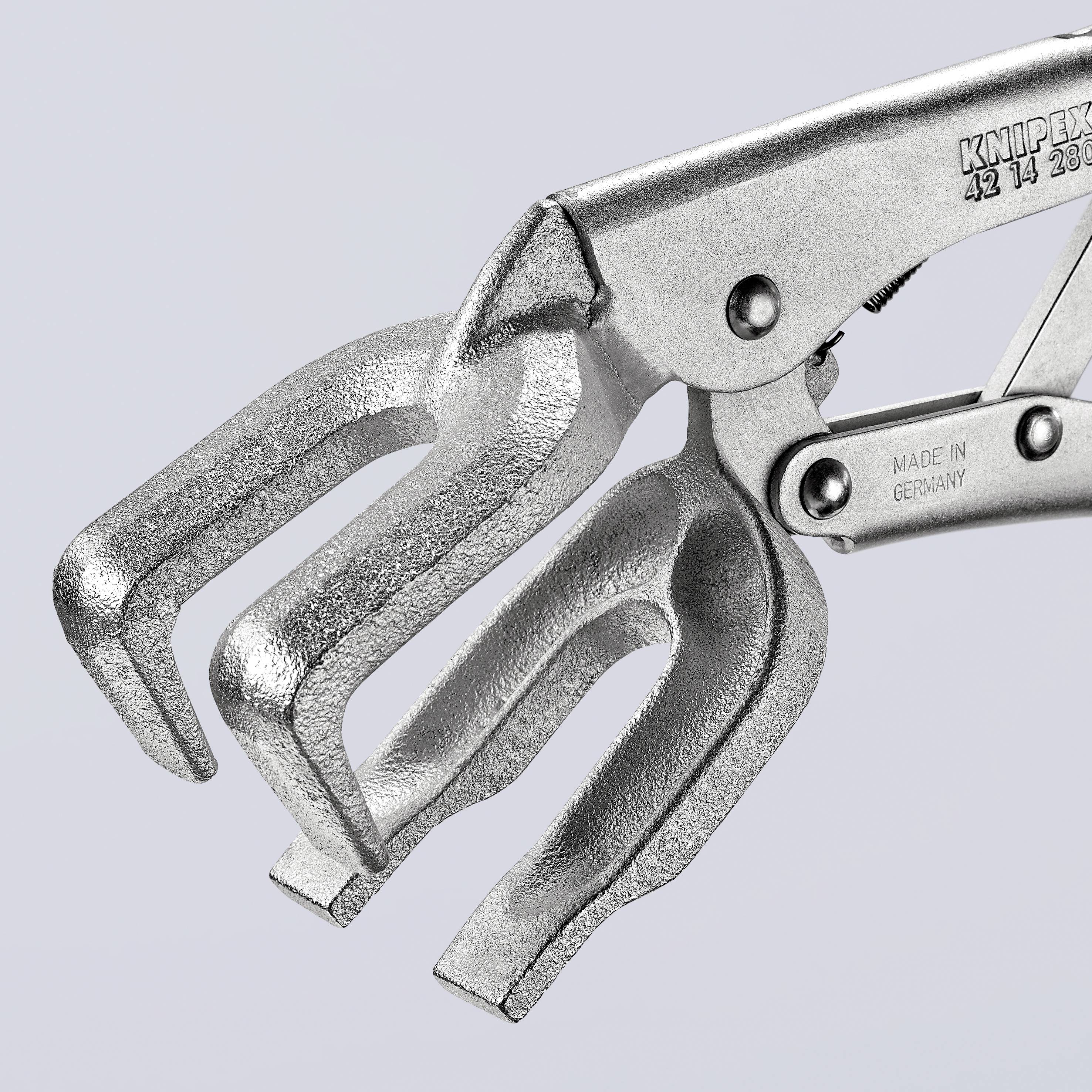 Una pinza d'argento con due aperture, con un riflesso metallico lucente. Marcature 'Made in Germany' sul metallo.