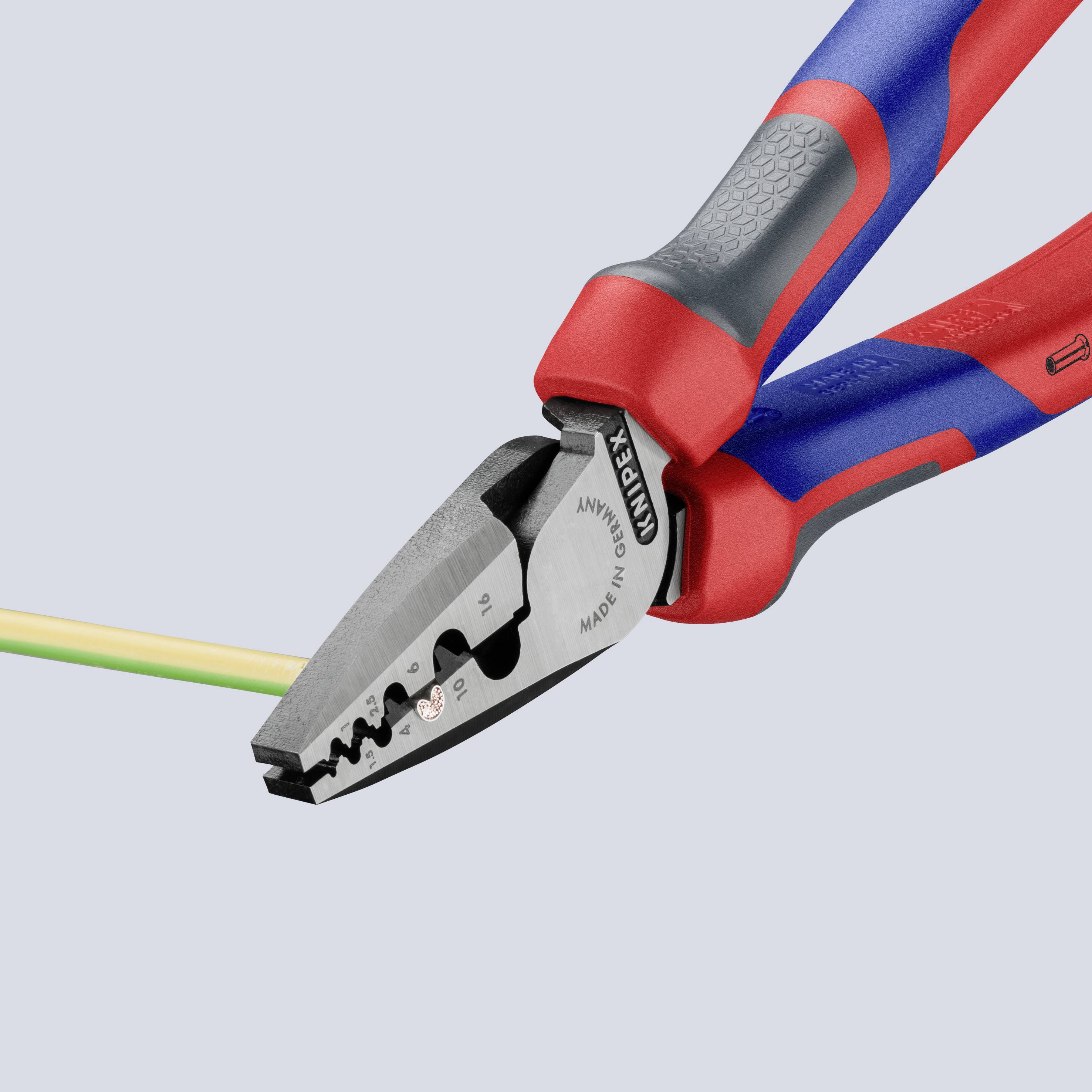 Una pinza combinata rossa e blu taglia un cavo multicolore. È mostrata in primo piano, enfatizzando precisione e funzionalità.