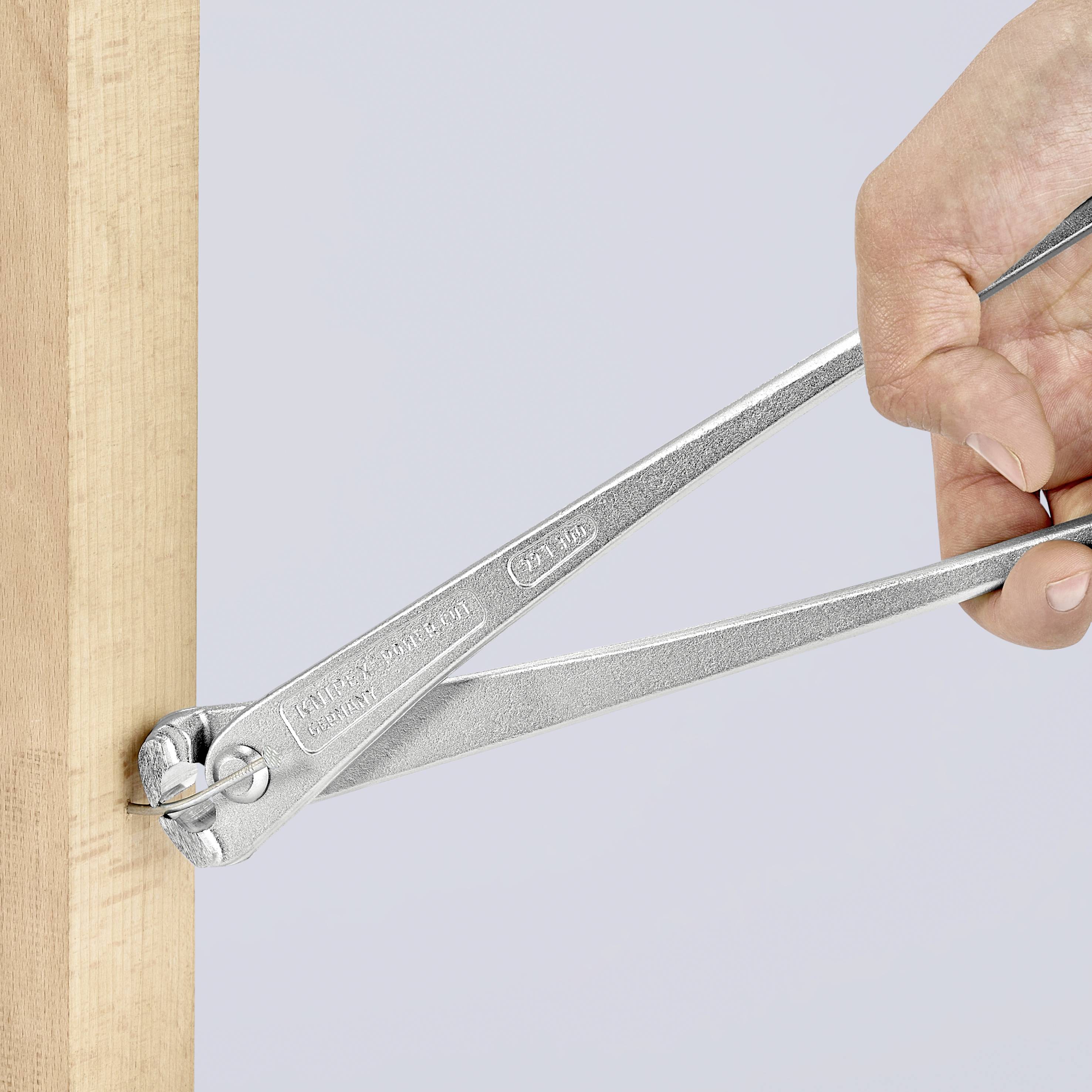 Una mano tiene un compasso che misura lo spessore di una trave di legno.