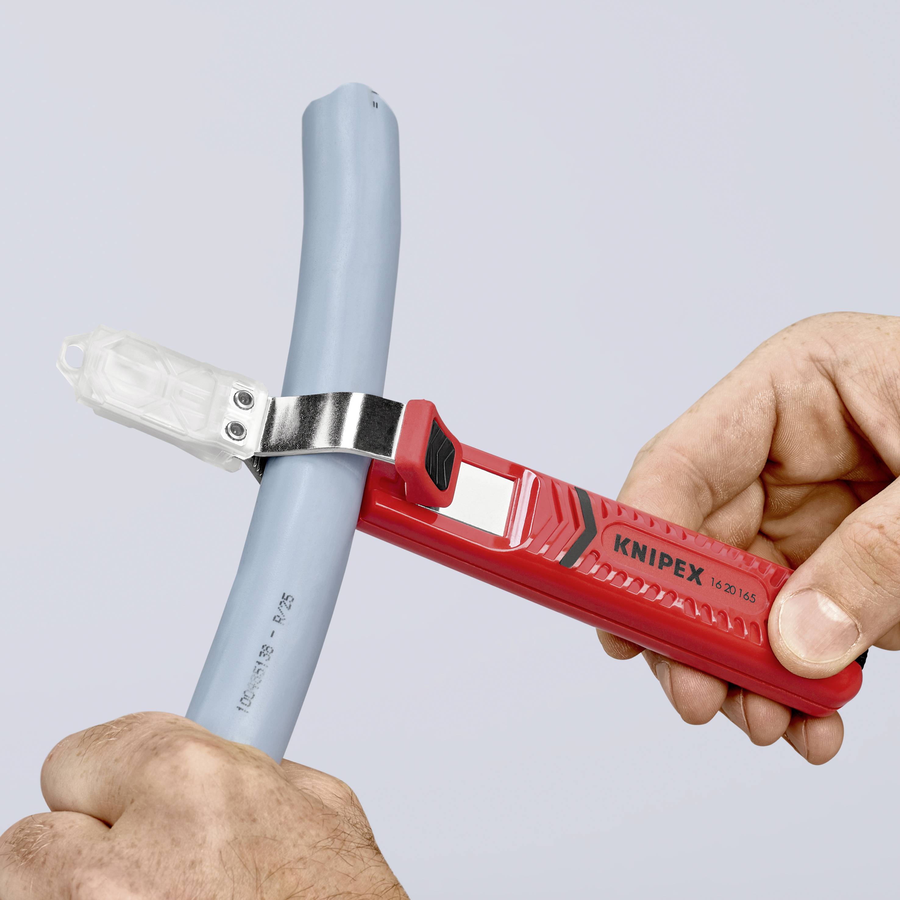 Una mano tiene un utensile Knipex per spellare che circonda un cavo per rimuovere l'isolamento in modo sicuro.