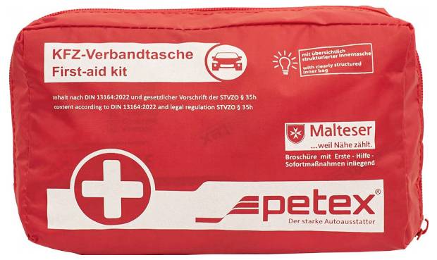 'Kit di primo soccorso rosso etichettato "KFZ-Verbandtasche" e "First-aid kit" con simbolo della croce bianca, prodotto da Petex, conforme a DIN 13164 e normative di legge.'