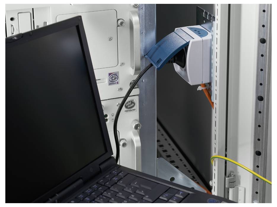 Un laptop è collegato a un armadio di rete. Un cavo di rete collega il laptop a una presa nell'armadio.