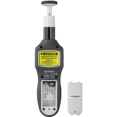 Uno strumento di misurazione con un avviso giallo che recita: 'Attenzione radiazione laser non guardare nel fascio'. Accanto ad esso un coperchio del vano batterie.