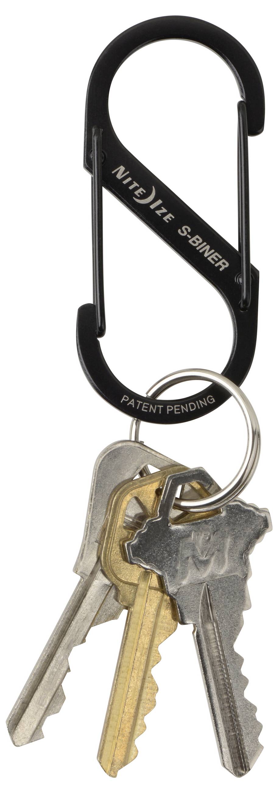 Un moschettone nero con l'etichetta 'Nite Ize S-Biner' trattiene tre chiavi metalliche su un portachiavi.