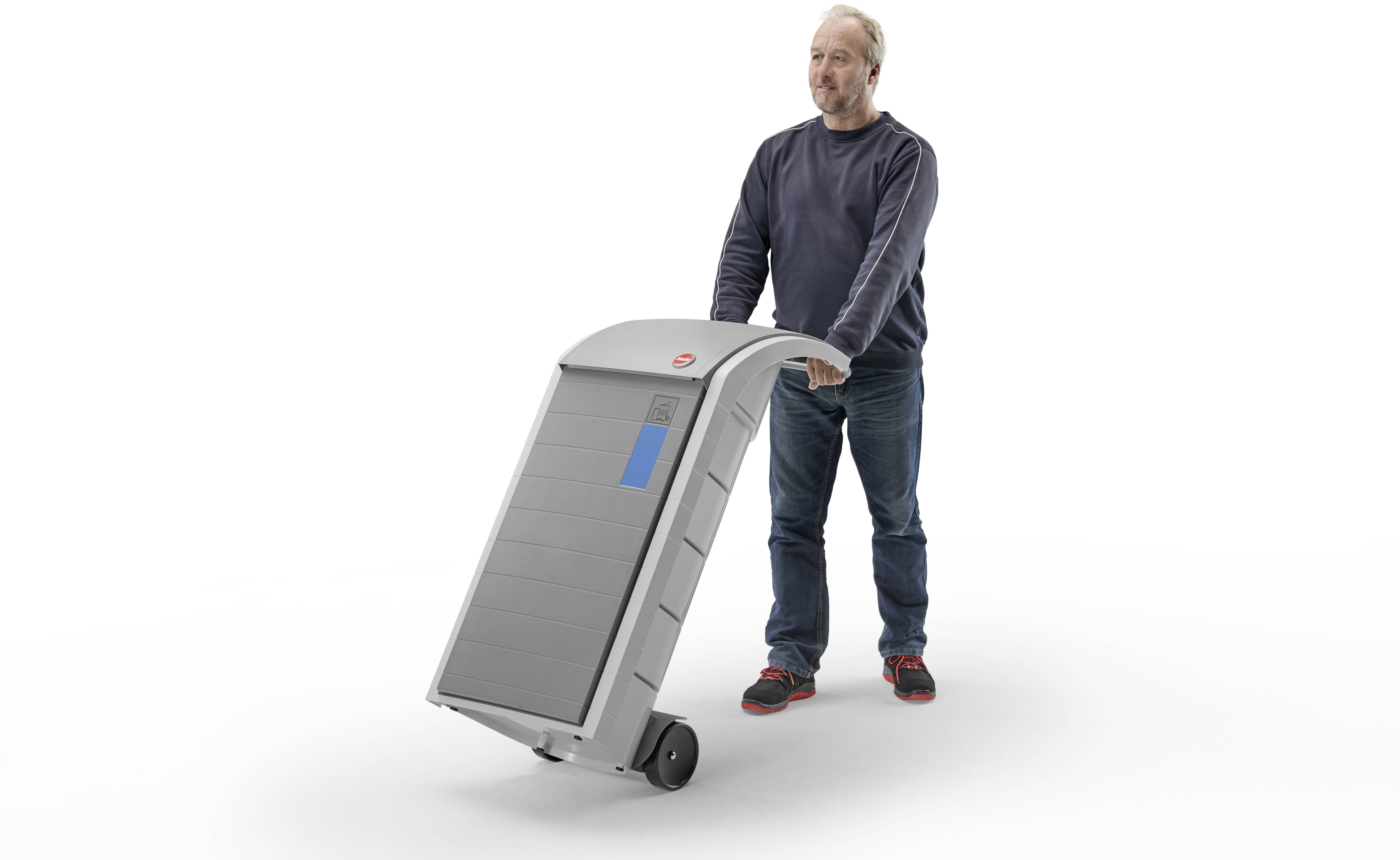Un uomo spinge un cassonetto dei rifiuti moderno, alimentato a energia solare con ruote. Il contenitore ha un display digitale e una superficie con pannello solare.