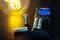 Caricabatterie carica batterie AA, illuminato da una lampadina. Due batterie aggiuntive sono posizionate accanto. Tema: Gestione energetica.