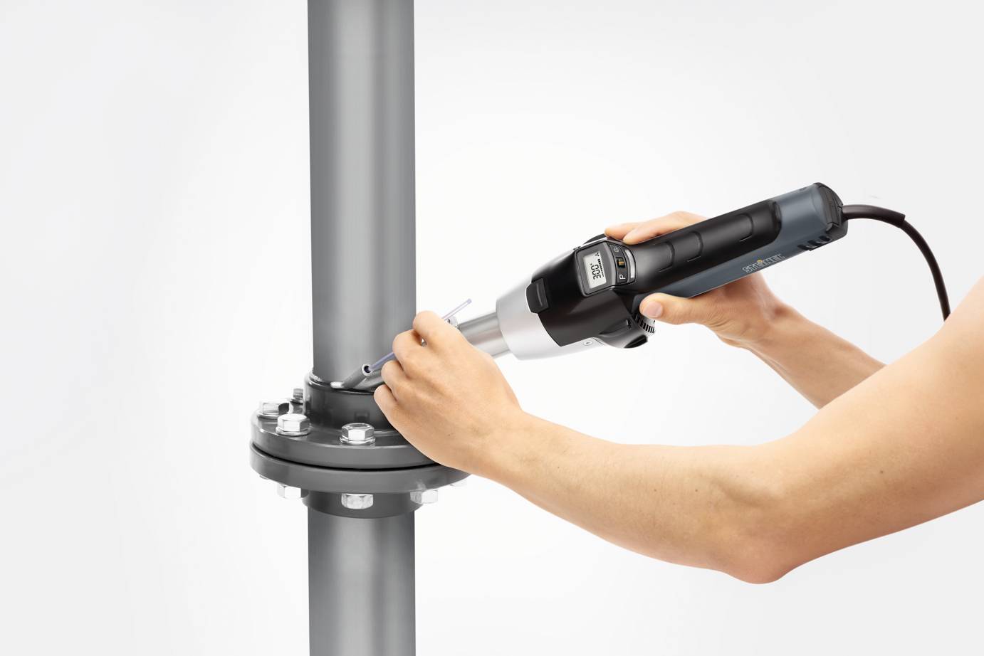 Una persona serra le viti di un giunto tubiero utilizzando una chiave dinamometrica elettrica.