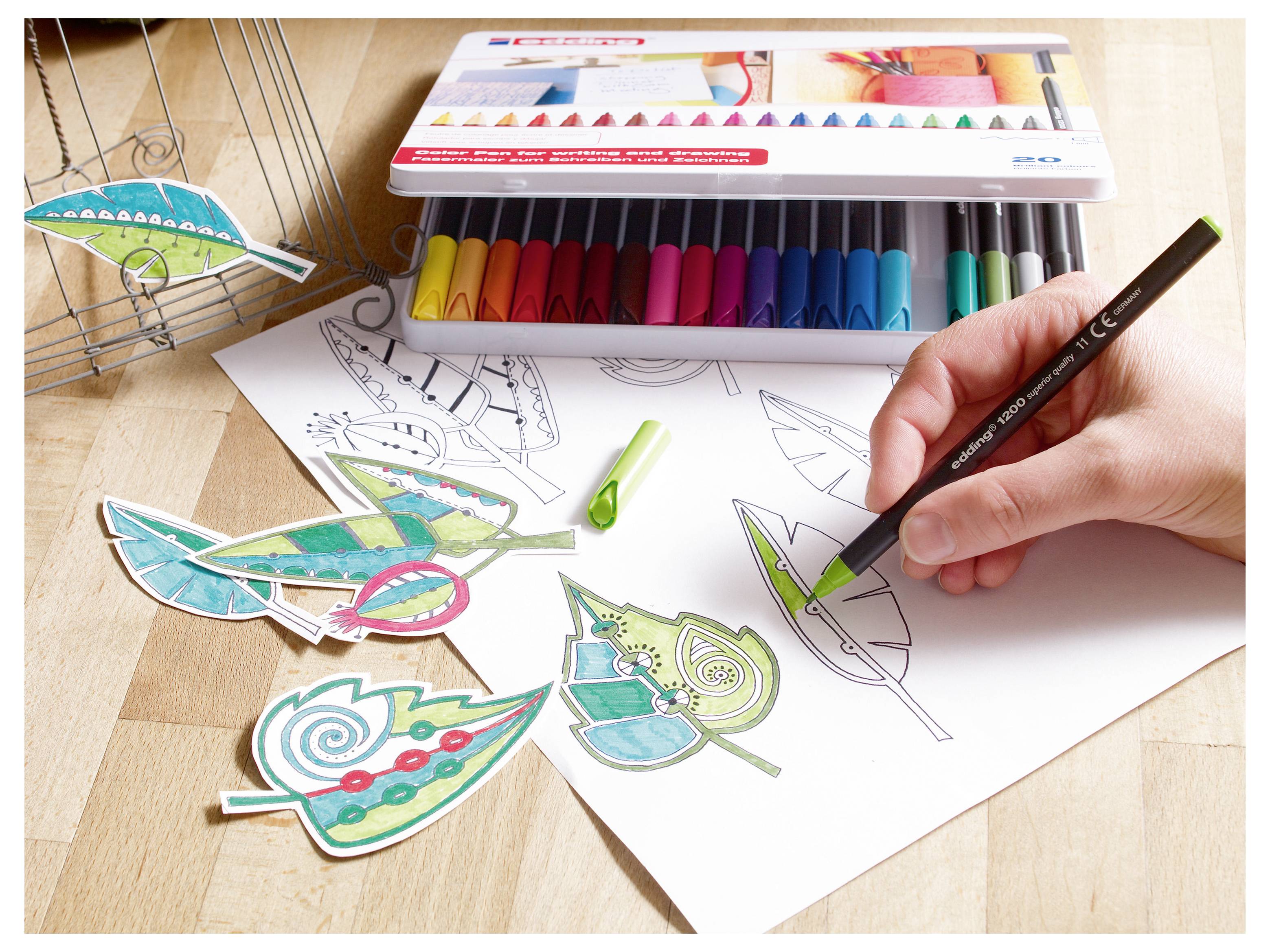 Disegnare a mano e colorare design a forma di foglia su carta con pennarelli colorati, con foglie di carta decorativa finite accanto allo schizzo.
