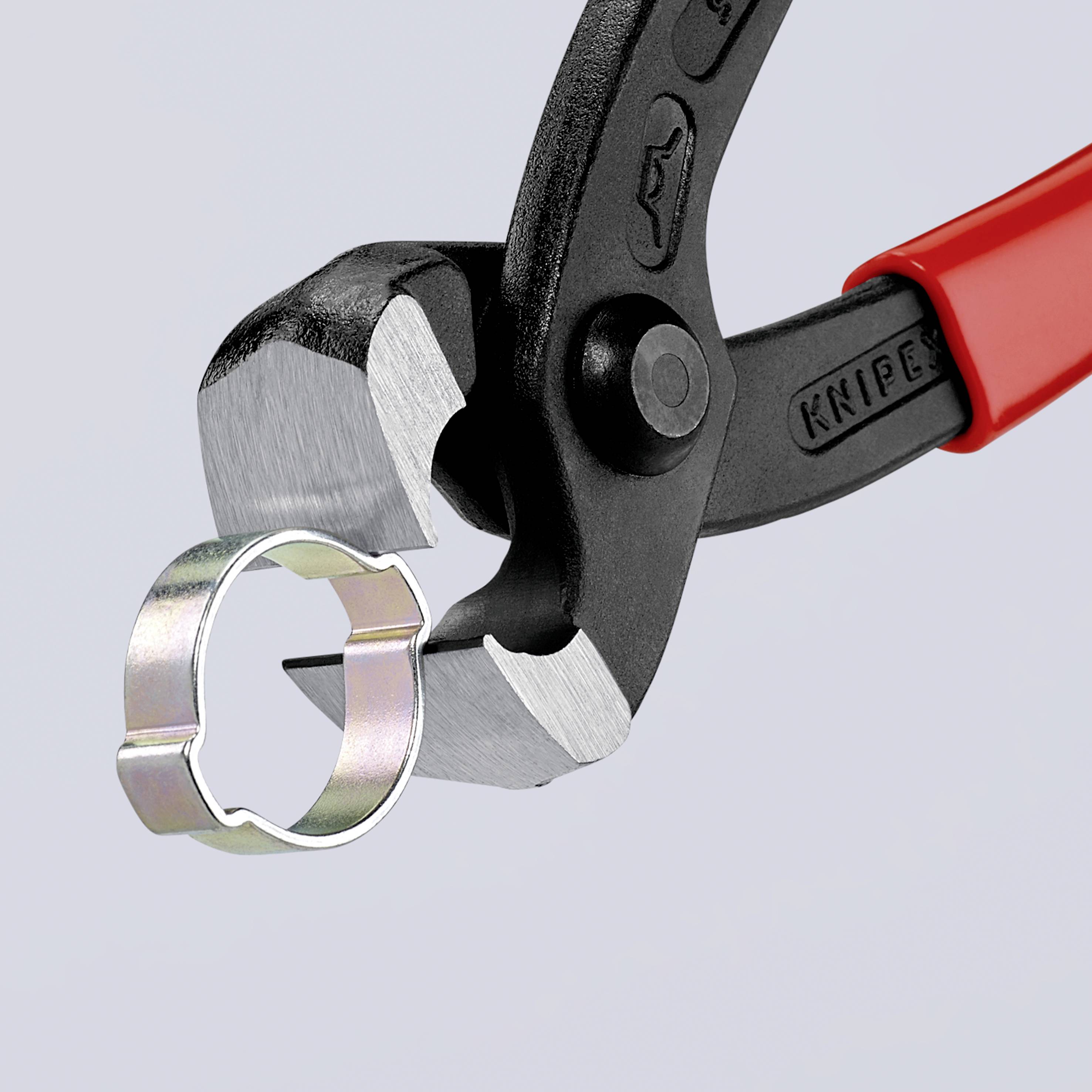 Una pinza con manico rosso tiene un anello d'argento.