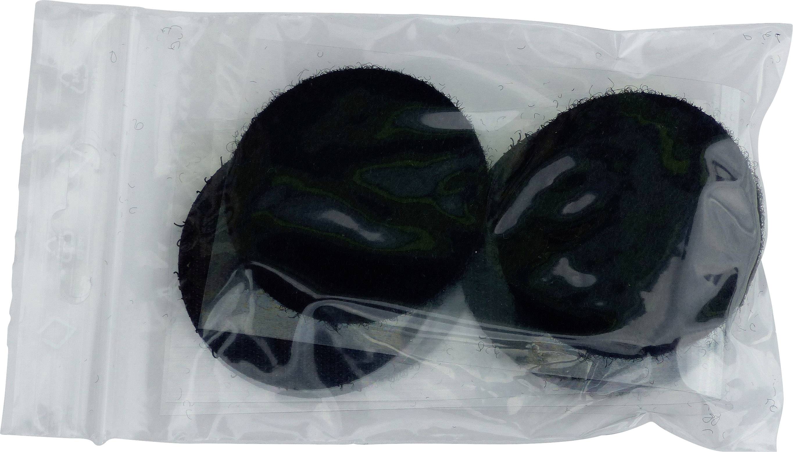 Due palline di muschio nere e rotonde in un imballaggio di plastica trasparente.