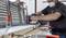 Un uomo sta levigando una tavola di legno con una levigatrice in un laboratorio. Indossa occhiali protettivi e una maschera.