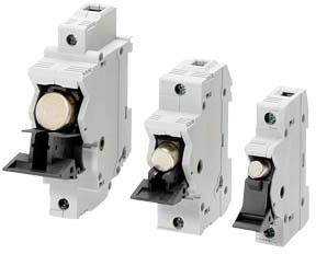 Tre interruttori automatici elettrici bianchi di dimensioni diverse sono disposti uno accanto all'altro su uno sfondo neutro.