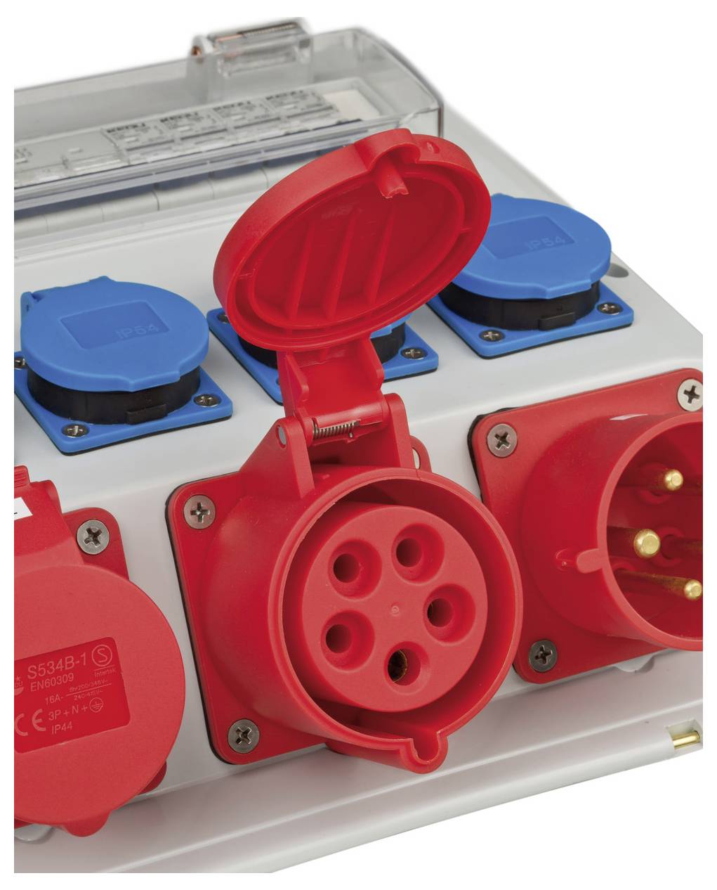 Primo piano di una scatola di distribuzione elettrica industriale con prese e spine rosse e blu, che mostra molteplici spine e prese elettriche con coperture protettive.