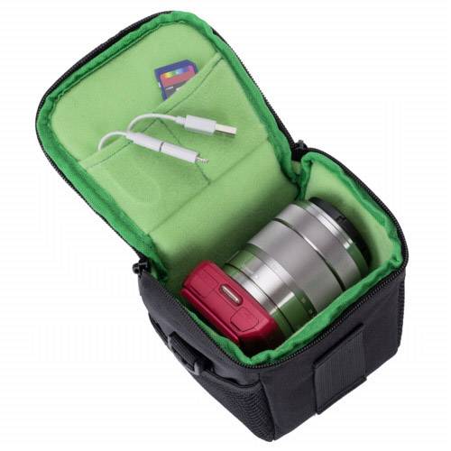 Una borsa fotografica con coperchio aperto mostra una fotocamera, due obiettivi, un cavo USB e una scheda SD su tessuto verde.