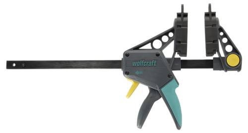Un morsetto rapido nero e verde acqua con logo 'wolfcraft', impugnatura a grilletto regolabile e doppi morsetti in plastica per lavori di falegnameria o progetti.