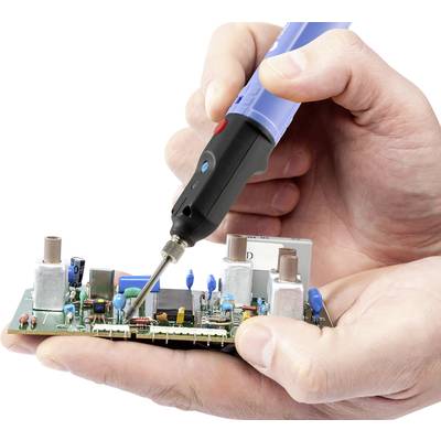 Una mano salda componenti su un circuito stampato utilizzando un saldatore. L'attenzione è incentrata sul lavoro tecnico preciso di componenti elettronici.