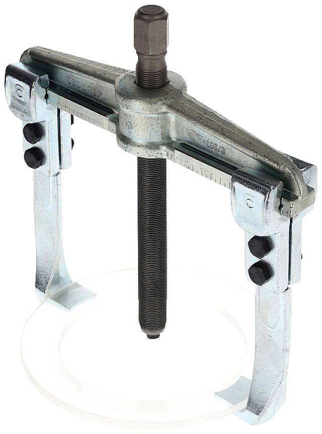 Estrattore a due bracci in metallo con vite centrale, poggiante su una lastra di vetro. Utensile per la rimozione di cuscinetti o pulegge.
