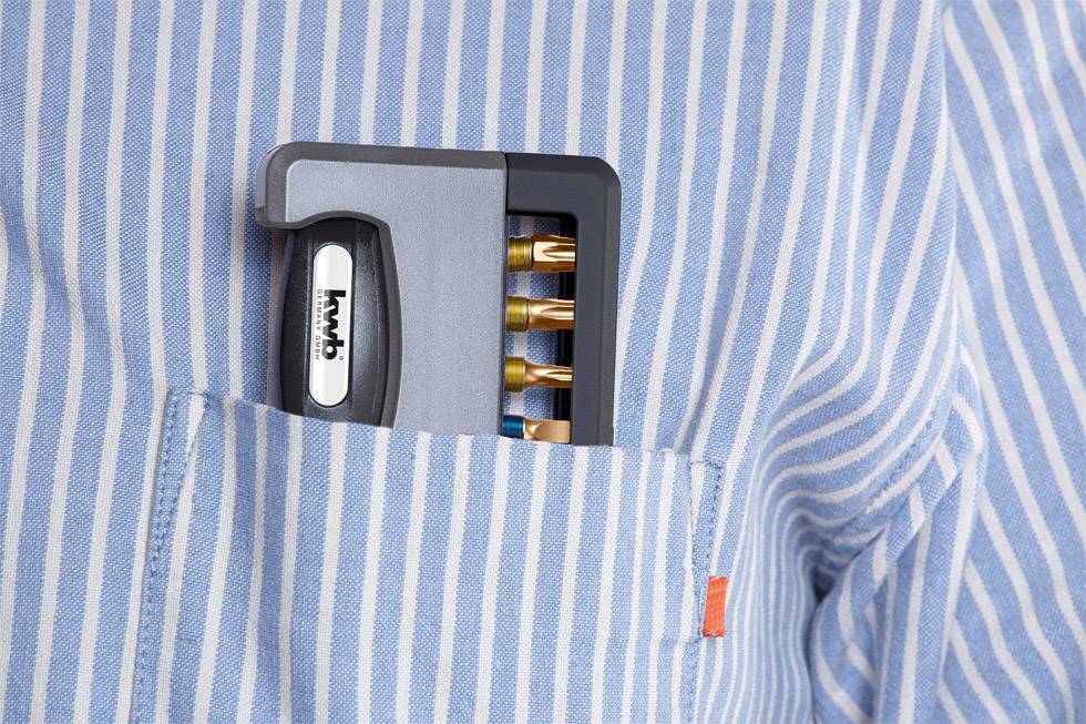 Un attrezzo multiuso in una tasca di una camicia a righe, con inserti degli strumenti di diversi colori visibili.