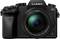 Fotocamera digitale reflex nera con obiettivo zoom, marca 'Lumix G'.