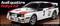 Un modellino di un'Audi Quattro Rallye A2 in scala 1:10, decorato con adesivi da rally e fari, esposto su una superficie.