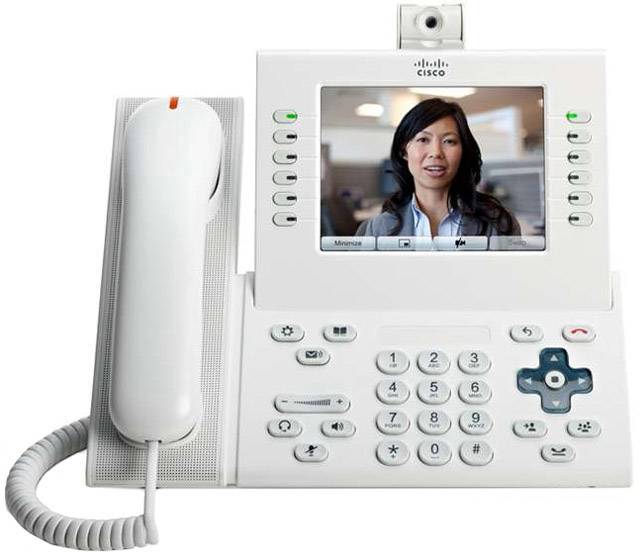 Un telefono video bianco con un grande display mostra una donna durante una videochiamata. Il telefono ha una tastiera e un ricevitore.