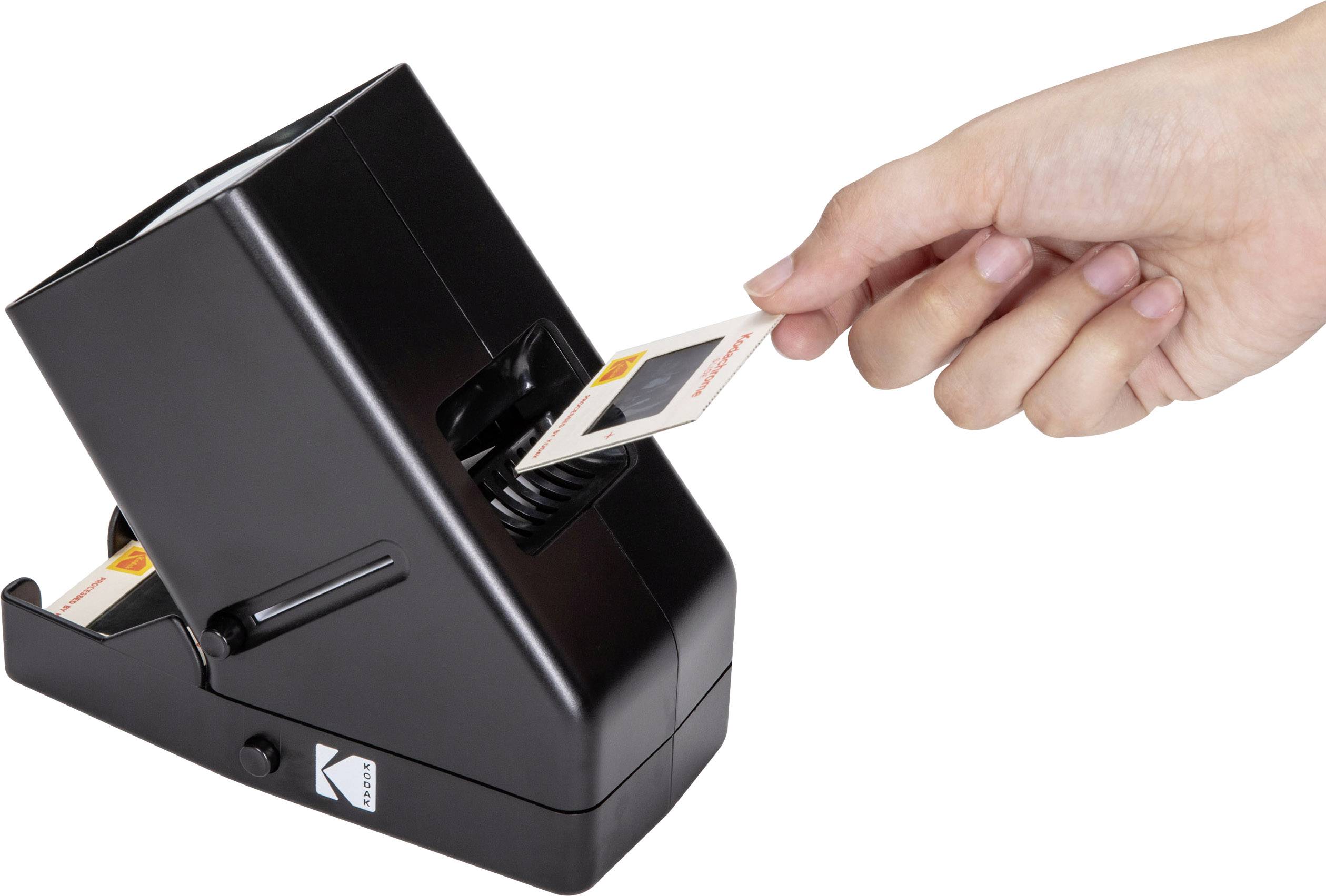 Una mano inserisce una diapositiva in un visualizzatore nero per diapositive, posizionato su un tavolo.