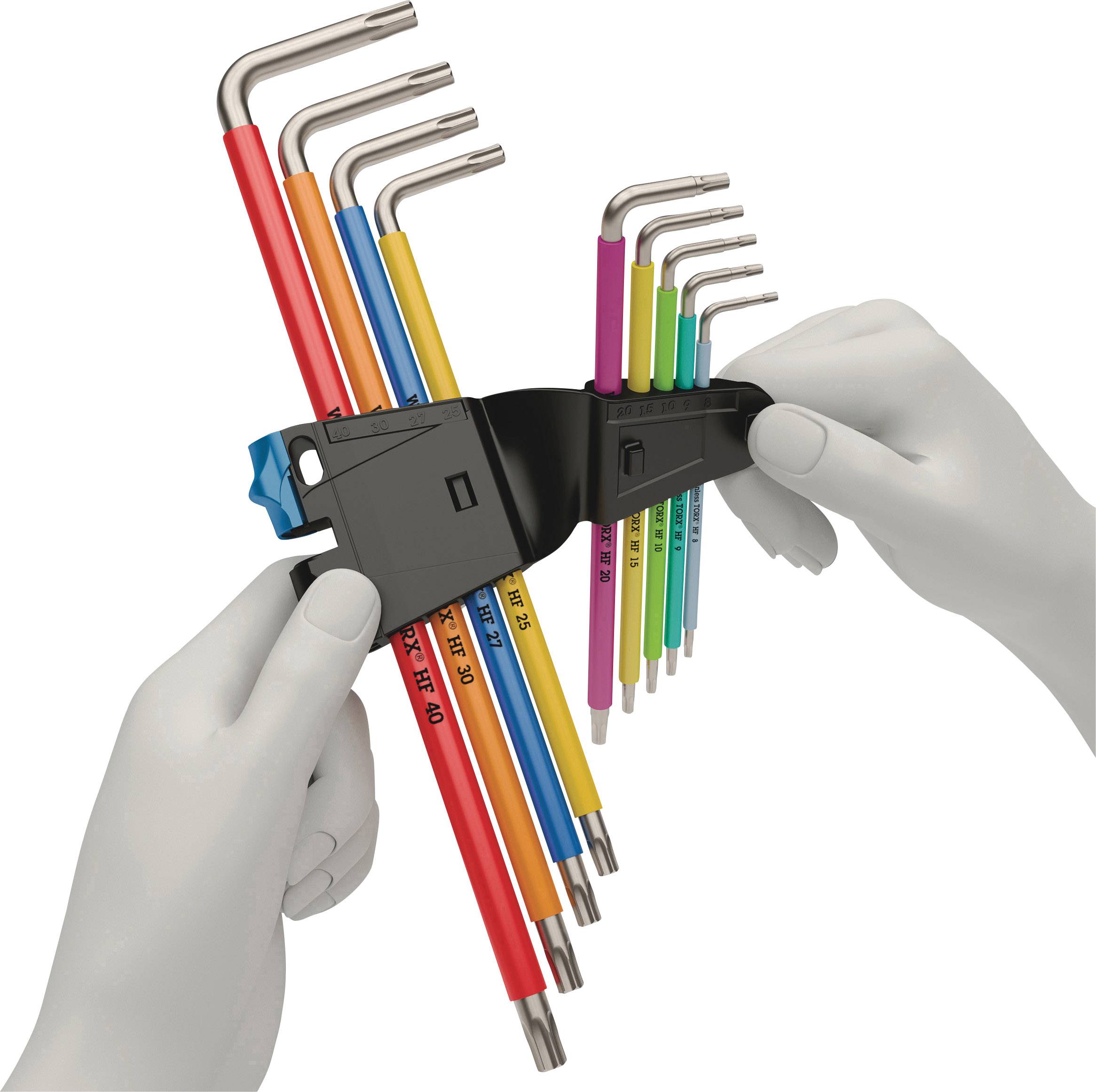Una persona tiene un set di chiavi a brugola colorate in un supporto nero. Le chiavi sono di dimensioni diverse e contrassegnate.