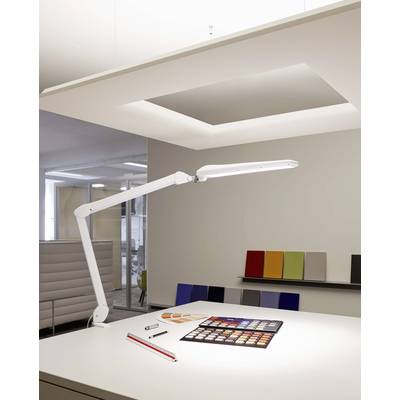 Un ufficio moderno con una lampada da scrivania bianca, campioni di colore e accessori di design sul tavolo; interni minimalisti.