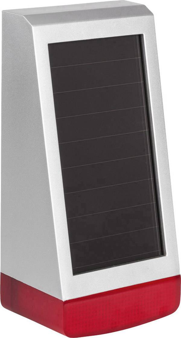 Dispositivo argentato, alimentato a energia solare, con pannello solare nero e base rossa, probabilmente un'illuminazione o un dispositivo di allarme.