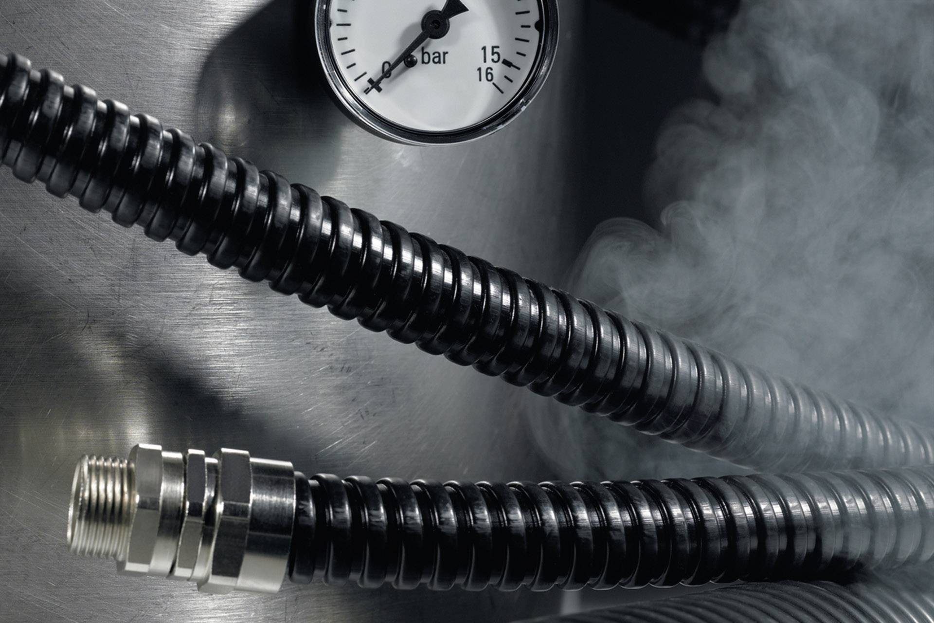 Un tubo metallico con indicatore di pressione mostra 1 bar. Fuoriesce vapore, segno di pressione o calore.