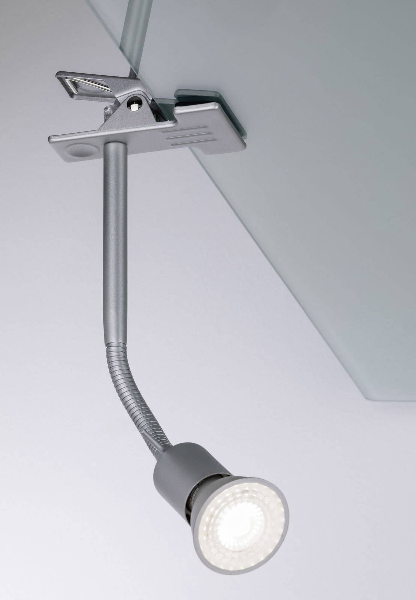 Lampada a morsetto in metallo con braccio flessibile e lampadina LED, fissata a una lastra di vetro, che illumina un'area del tavolo.
