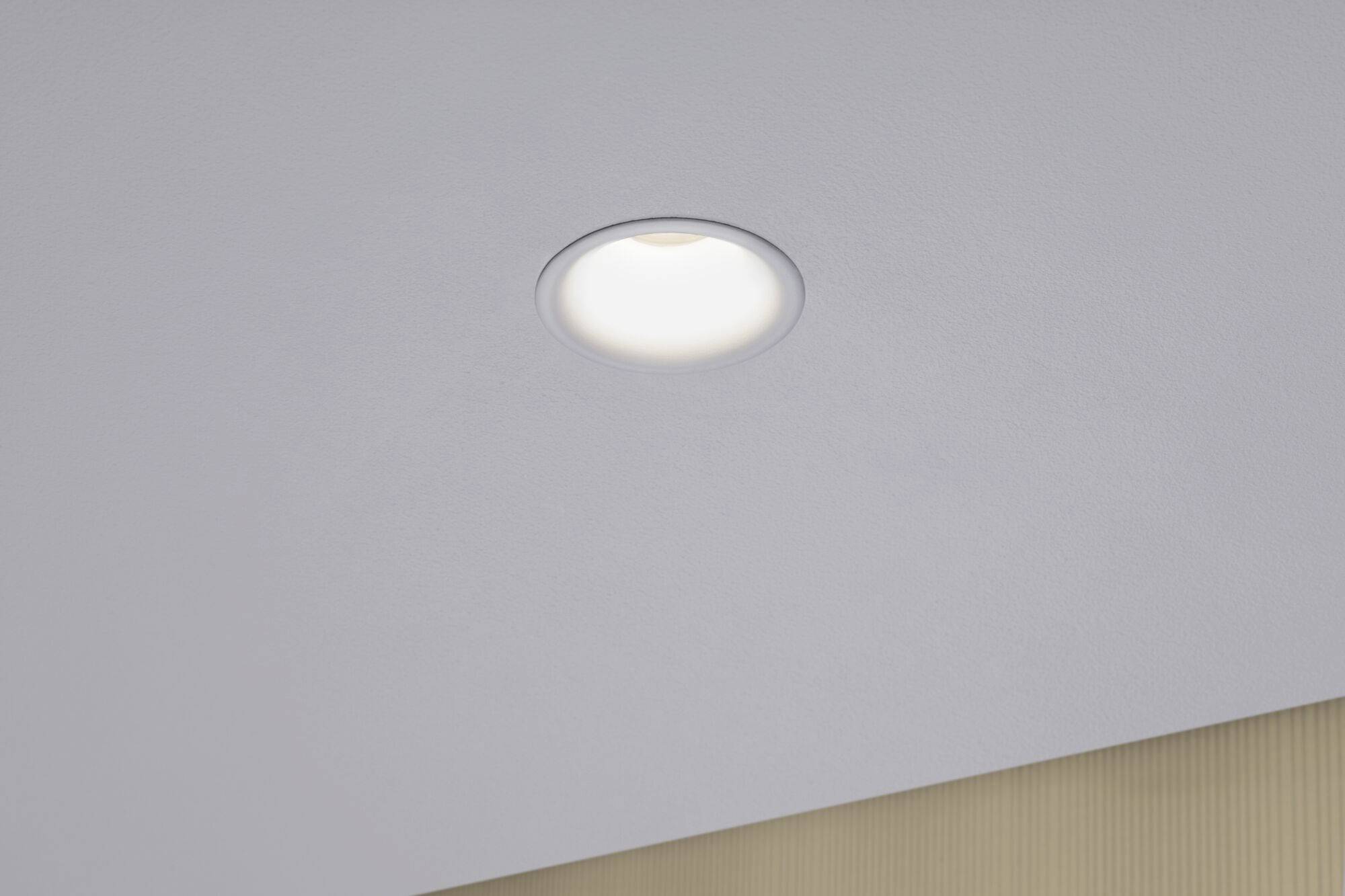 Faretto LED rotondo incassato a soffitto, illumina intensamente uno spazio moderno. Design minimale privo di cavi visibili.
