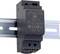 Un alimentatore nero per guida DIN con specifiche tecniche stampate. Adatto per installazioni elettriche, ingresso 18-75V, uscita 24V.
