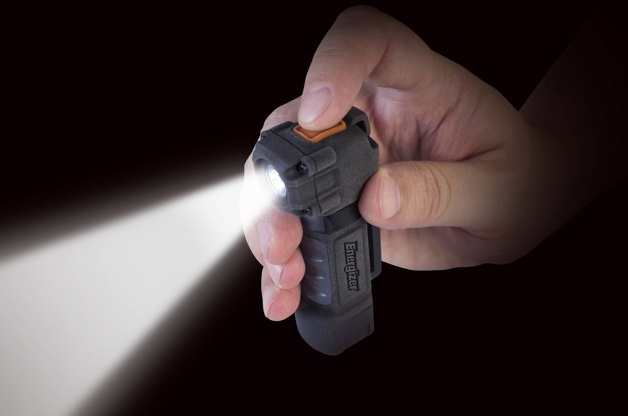 Una mano tiene una torcia elettrica accesa che emette un fascio di luce. L'ambiente è buio, il che enfatizza la luminosità della luce.