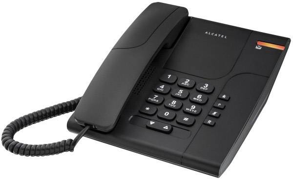 Un telefono fisso nero con tastiera, cornetta e cavo a spirale è posato su un tavolo.