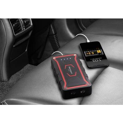 Una power bank è posizionata su un sedile dell'auto e sta caricando uno smartphone tramite un cavo USB. Il display del telefono mostra le informazioni di ricarica.