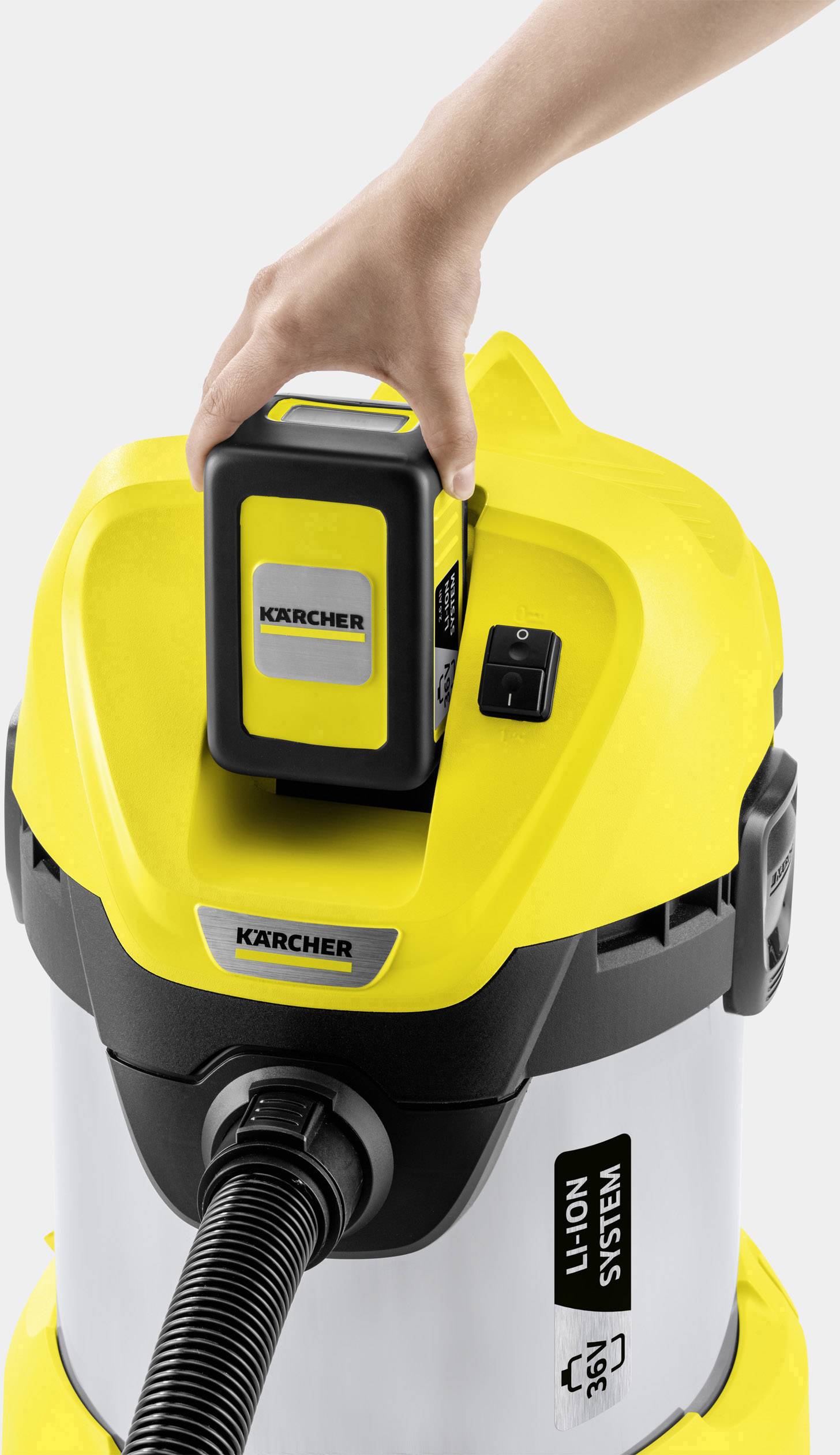 Una mano inserisce una batteria in un aspirapolvere industriale giallo Kärcher. L'aspirapolvere è dotato del "Sistema Li-Ion 36V".