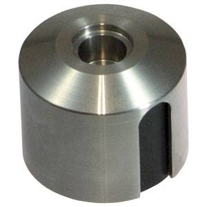 Un pezzo cilindrico in metallo con un foro centrale, che sembra essere stato lavorato meccanicamente. Ha una superficie lucida e un'apertura rettangolare sul lato.