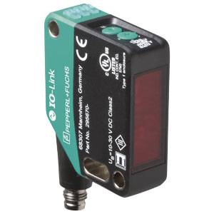 Sensore industriale di Pepperl+Fuchs con superficie superiore verde, custodia nera, finestra del sensore rossa e connettore IO-Link, con dettagli del modello visibili.