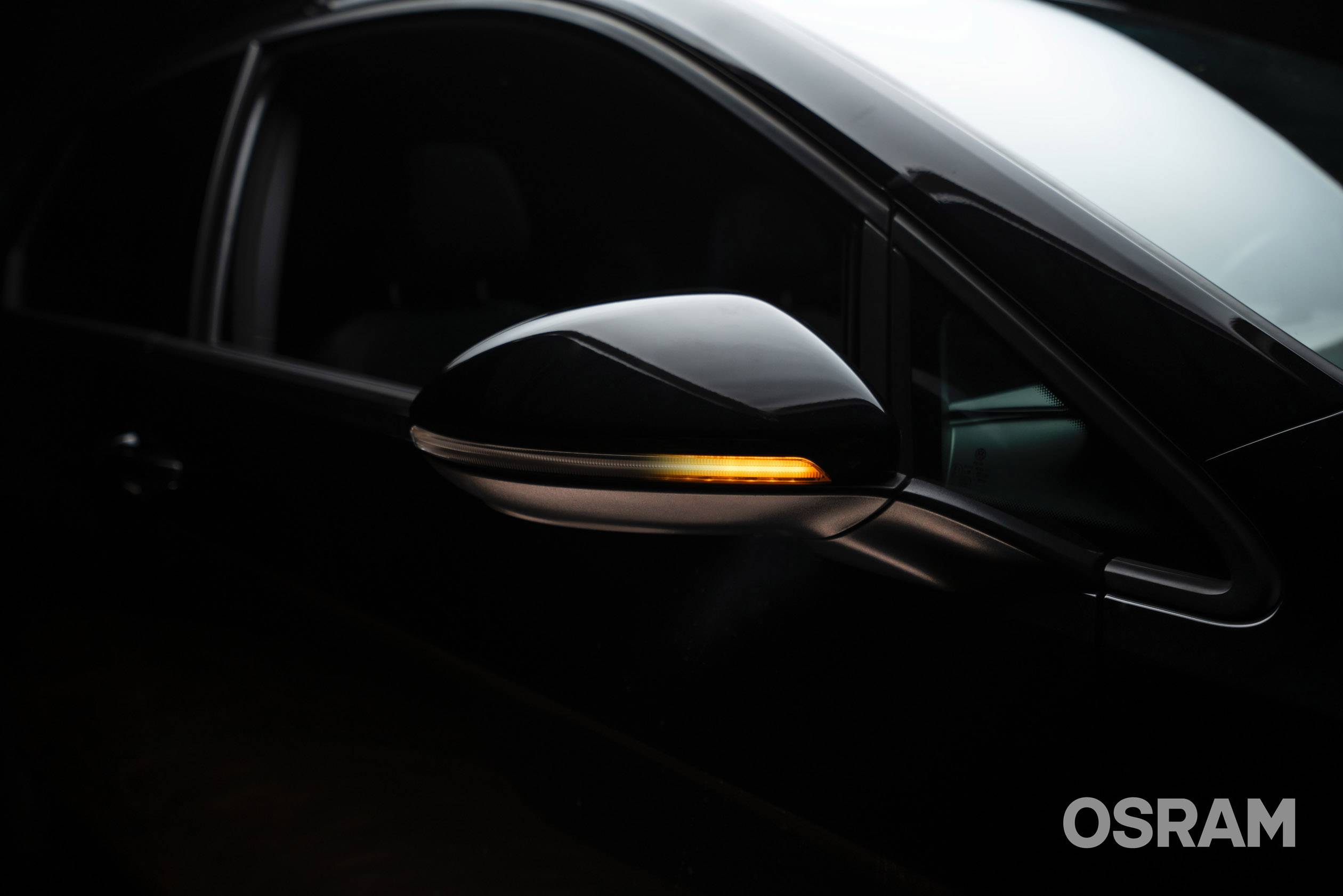 Auto nero con freccia laterale illuminata.