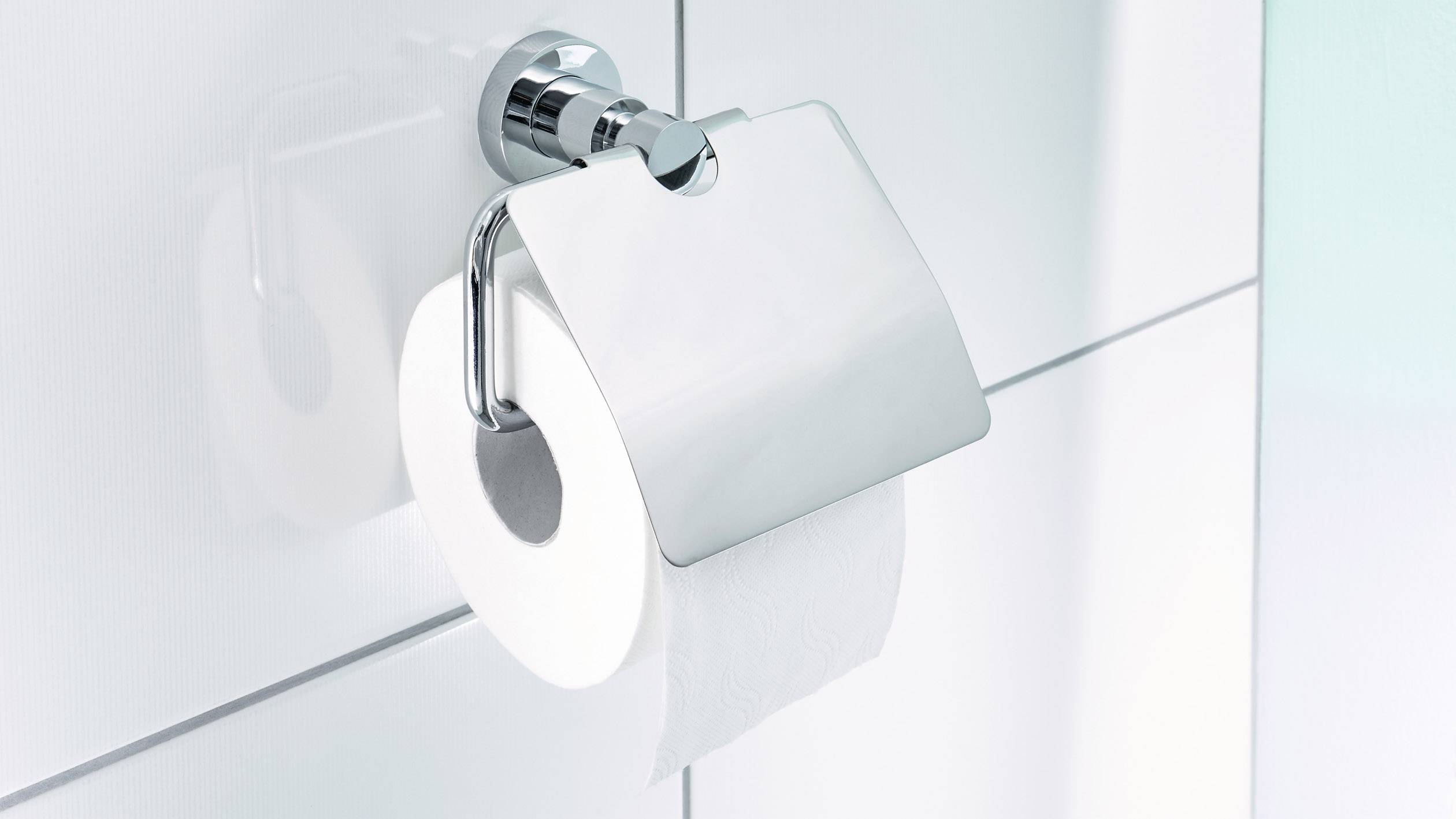 Rotolo di carta igienica su un supporto a parete in un bagno. L'ambiente appare pulito e moderno.
