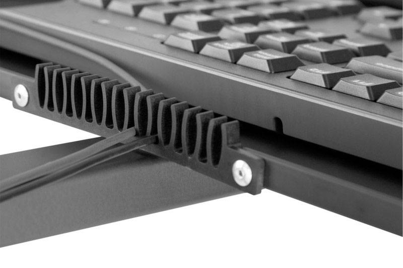 Primo piano di un cavo di una tastiera per computer che passa attraverso un fermacavo. Sullo sfondo è visibile una tastiera.