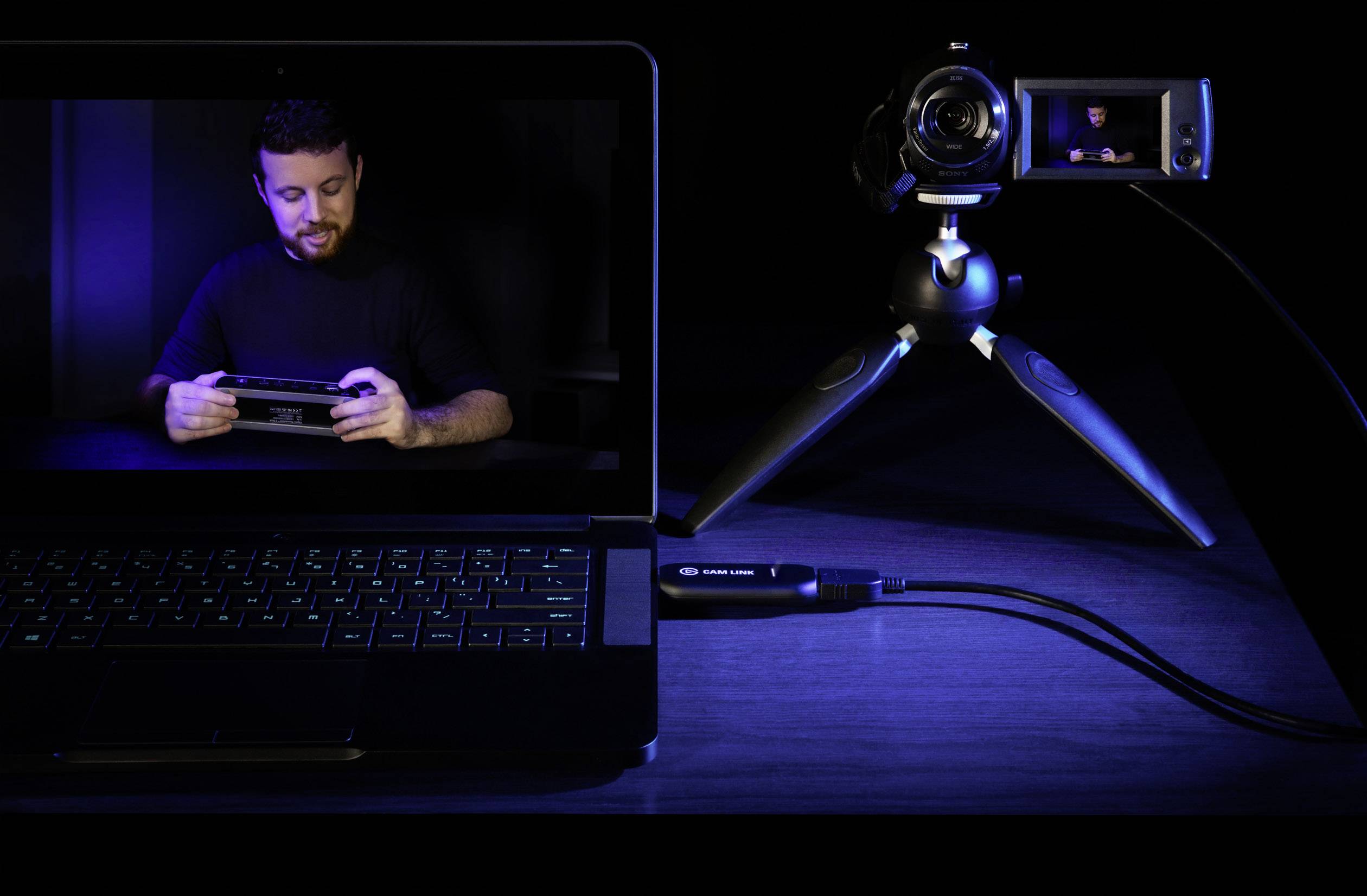 Un laptop mostra un uomo che tiene un dispositivo. Una fotocamera su un treppiede è collegata al laptop e mostra uno schermo simile.