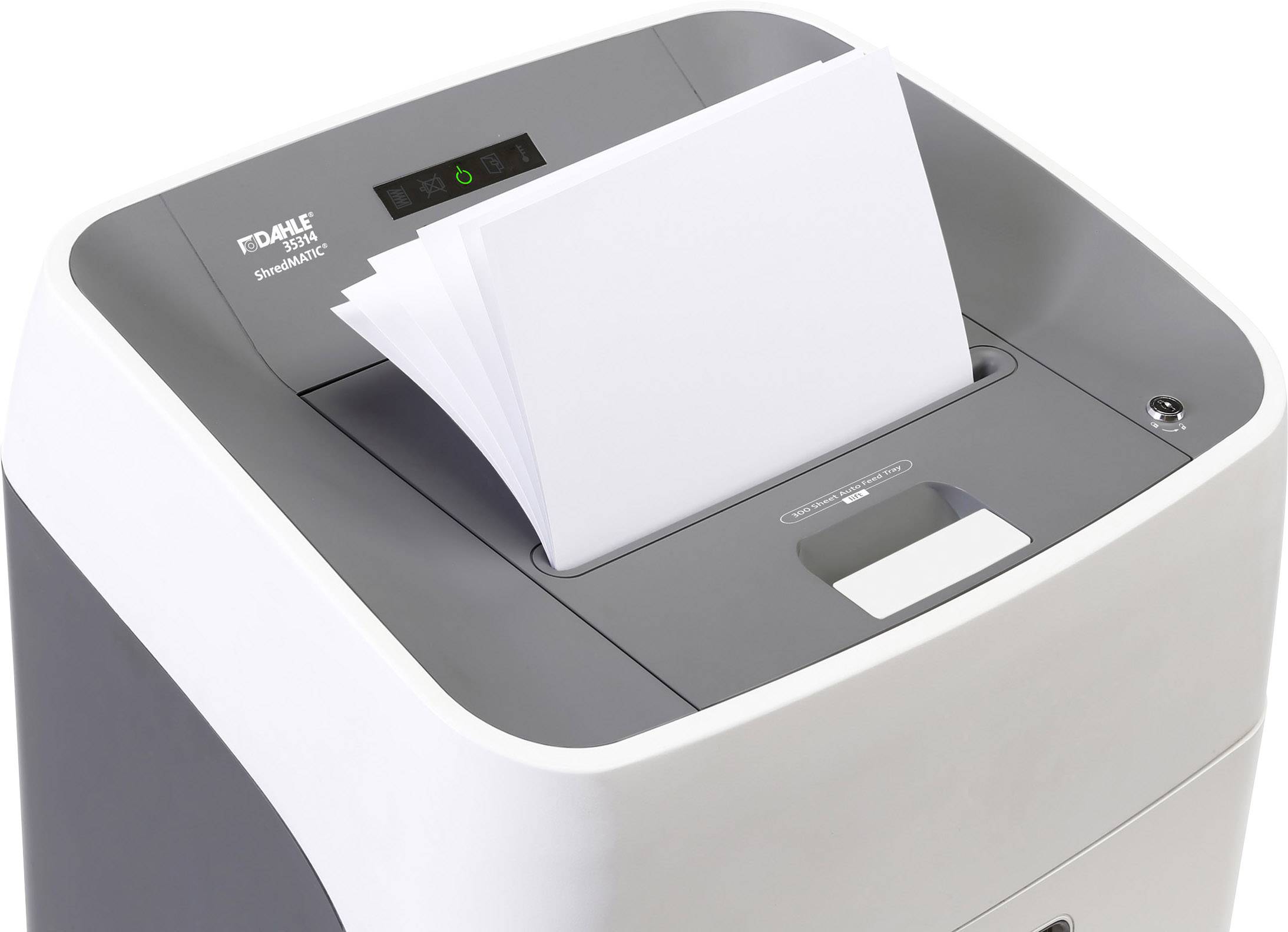 Una distruggedocumenti con diversi fogli di carta inseriti dall'alto. Il dispositivo è pronto all'uso, la spia verde di funzionamento è accesa.