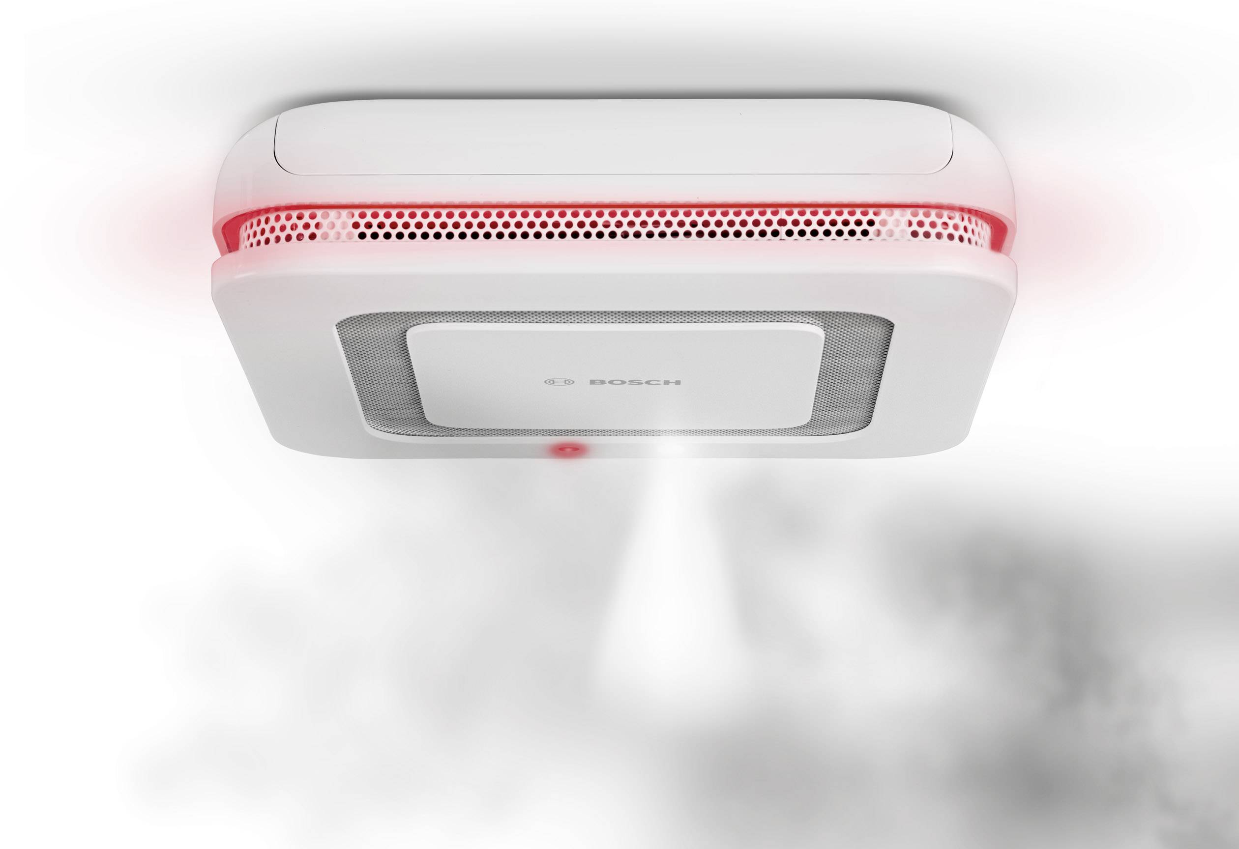 Rilevatore di fumo sul soffitto attiva l'allarme con luce rossa e fumo. La sicurezza in caso di incendio è segnalata.