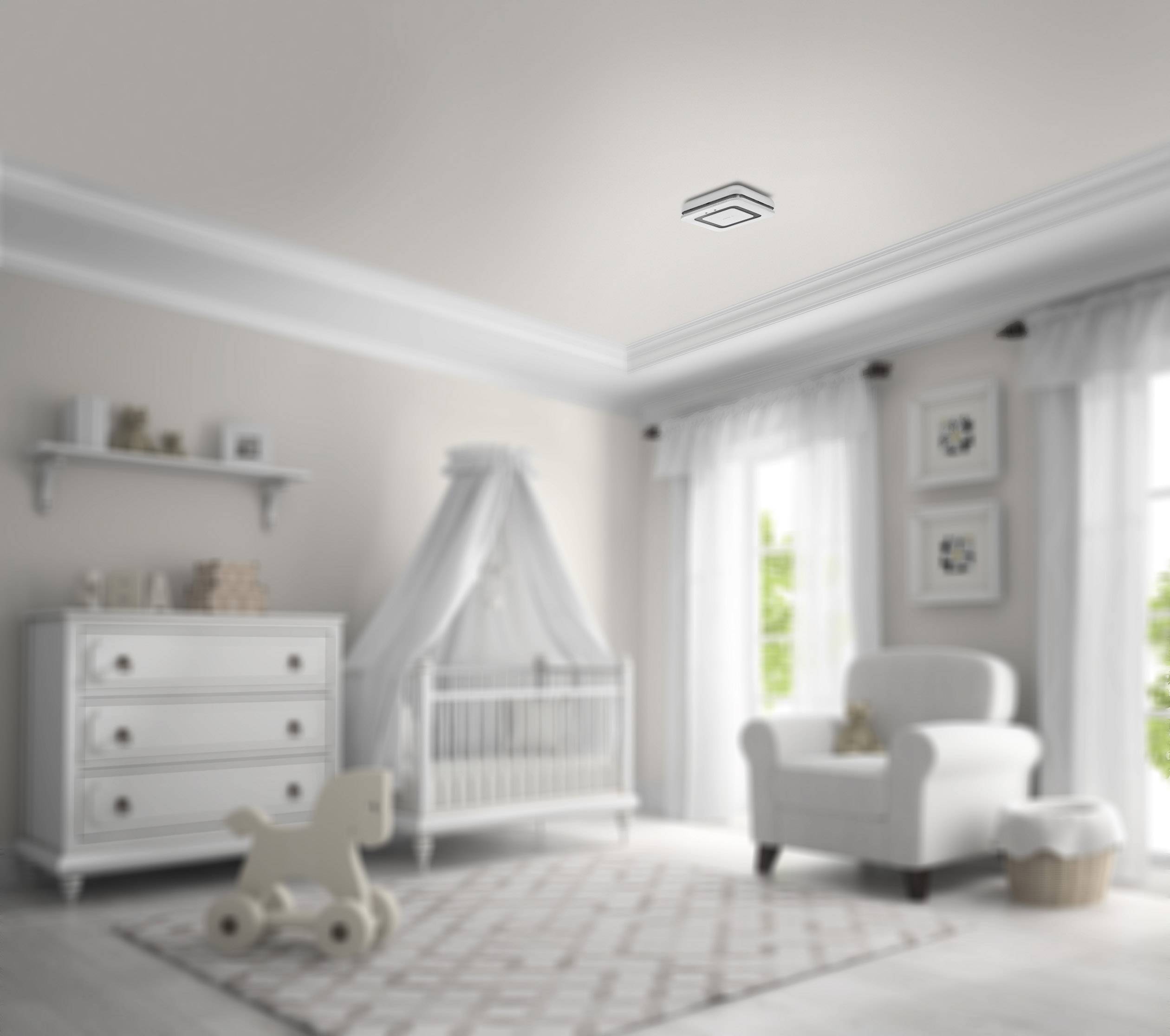 Una luminosa cameretta con un lettino bianco a spondine, una cassettiera e una poltrona. Le finestre, con tende trasparenti, lasciano entrare la luce del giorno.