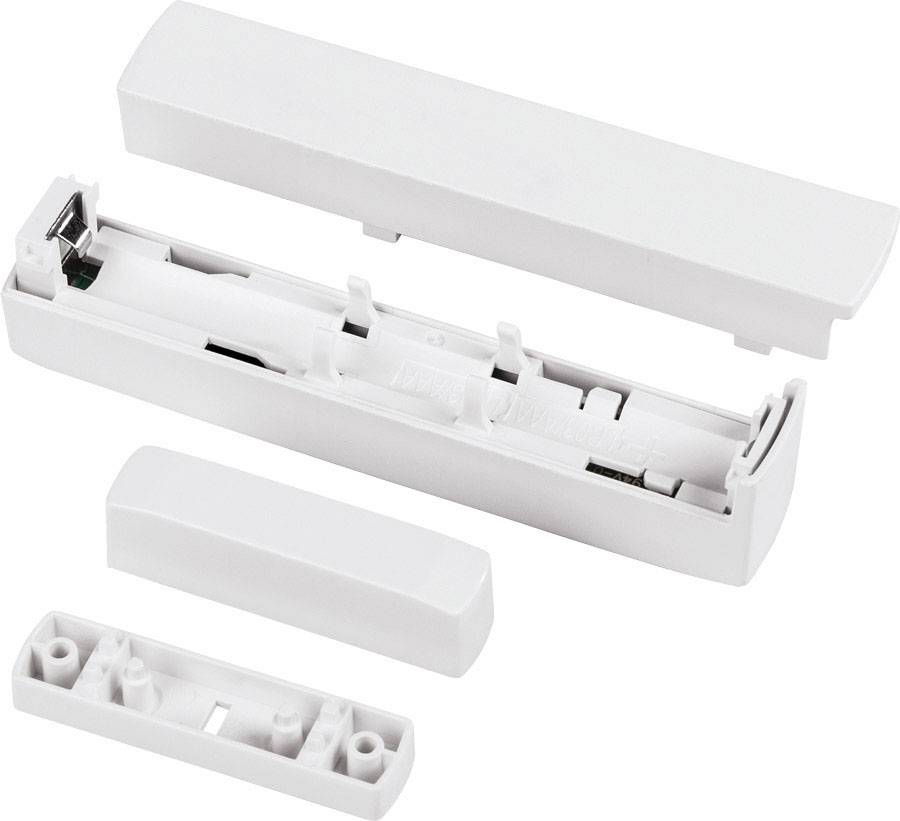 Un contenitore bianco in plastica smontato con diversi componenti che potrebbero contenere un meccanismo elettronico.