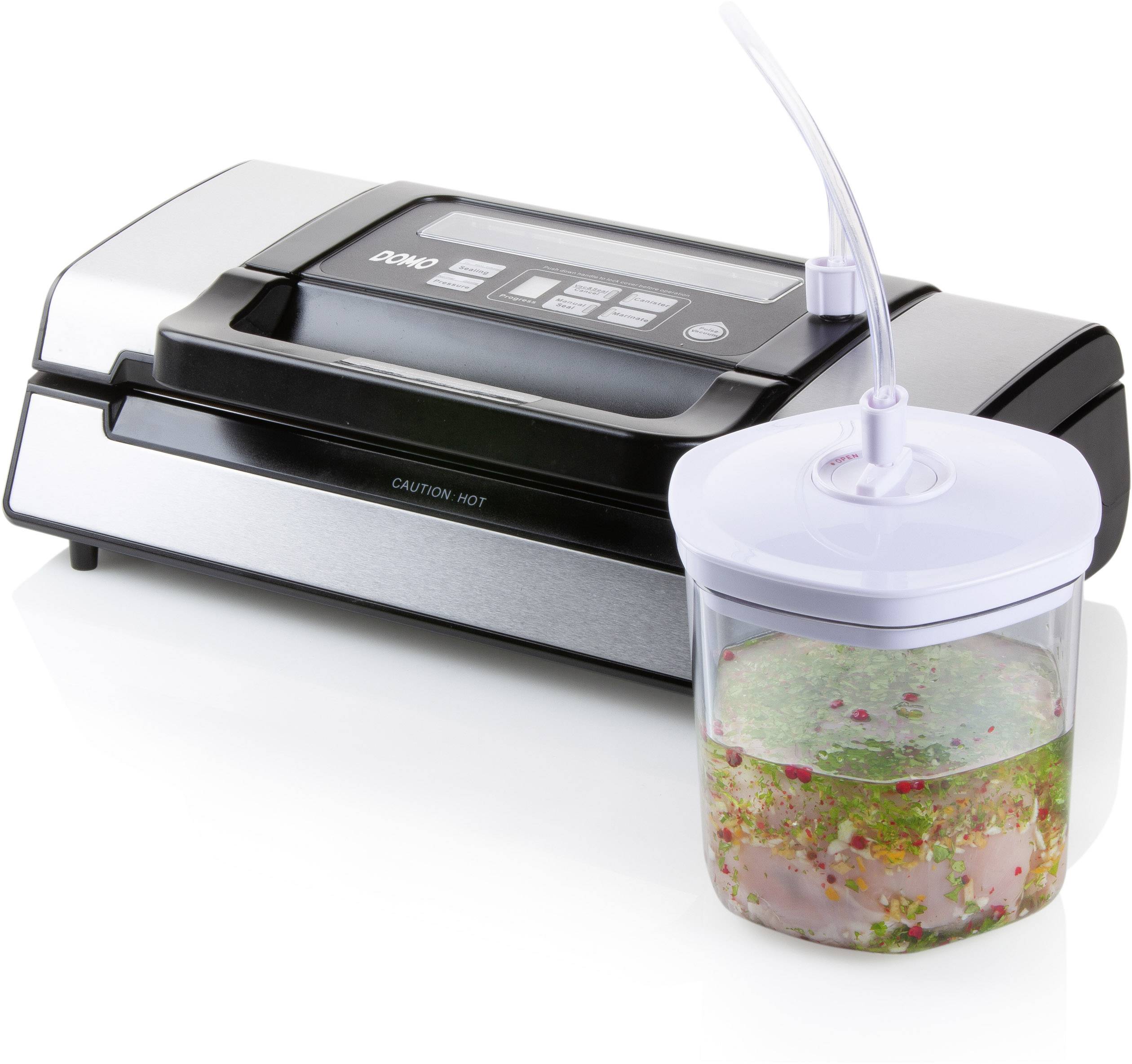 Macchina per sottovuoto con connessione a un contenitore per sottovuoto riempito di insalata fresca. L'apparecchio mostra i pulsanti di controllo sulla parte superiore.