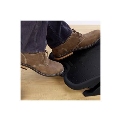 Una persona che indossa scarpe marroni preme un pedale poggiapiedi su un pavimento in legno, dimostrando il suo utilizzo per regolare l'altezza del poggiapiedi.