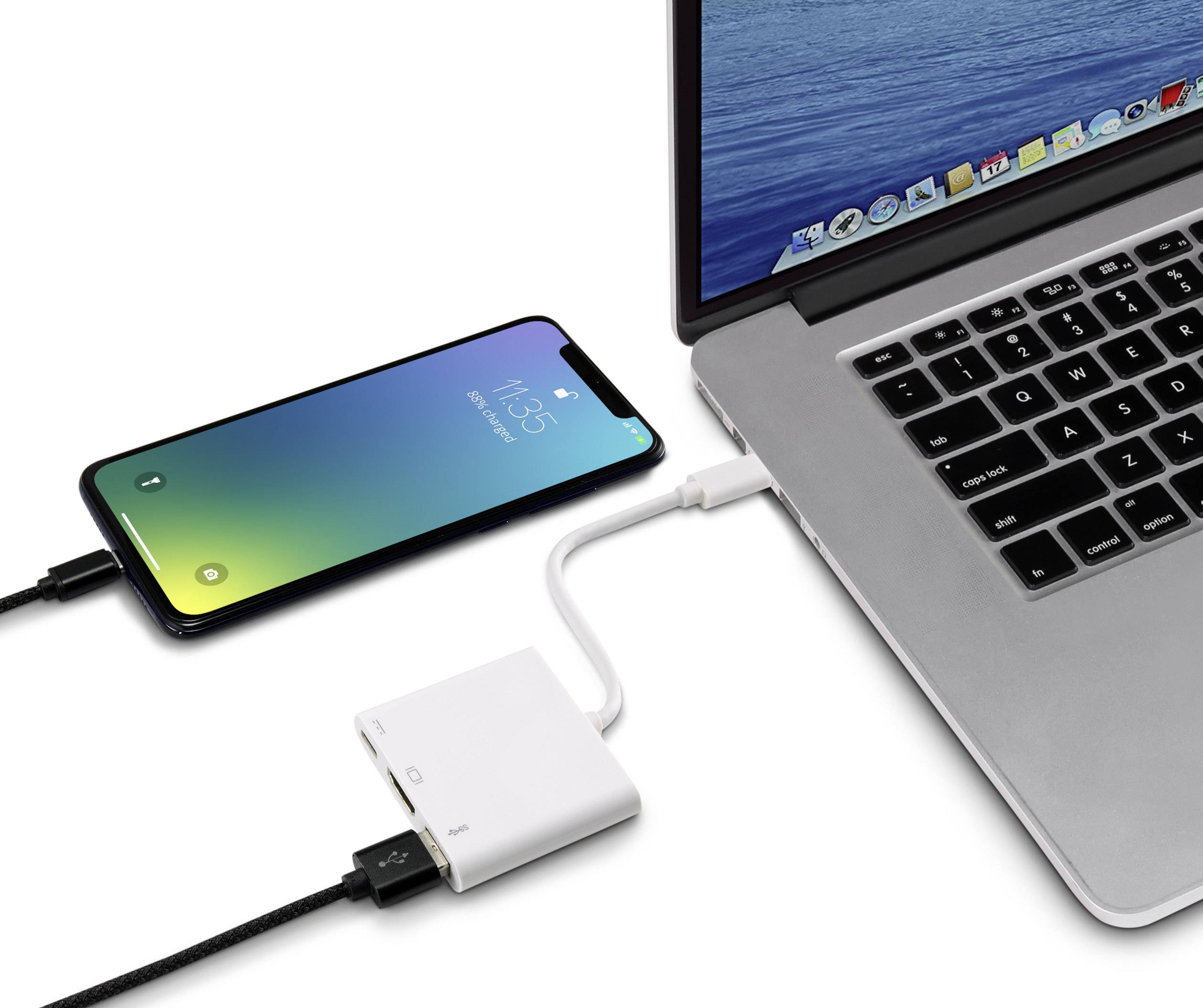 Lo smartphone viene collegato tramite un adattatore a un laptop poggiato su un tavolo. Lo schermo dello smartphone mostra lo stato di carica.